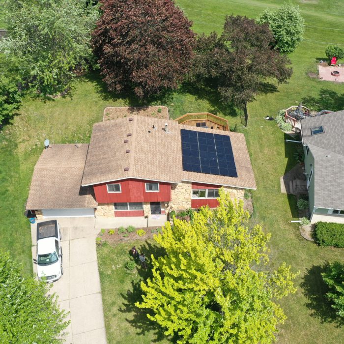 Solar panels arranged in a field with trees in the background - Residential Solar Power