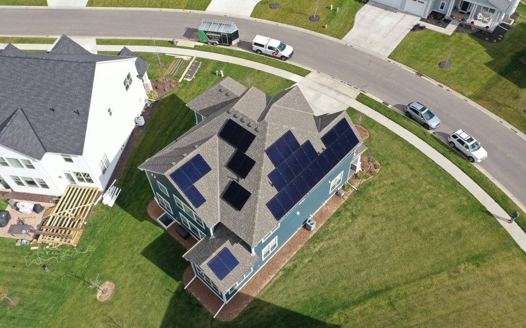 Aerial view of solar panels installed in a field under blue skies - Home Solar Panel Installation