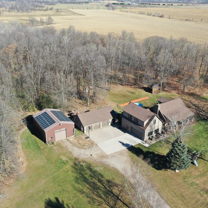 Aerial view of solar panels installed in a field under blue skies - Solar Panels For Home