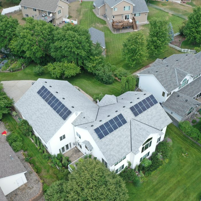 A beautiful aerial view of a solar panel farm, capturing rows of panels glistening under the sunlight - Residential Solar Panel Company