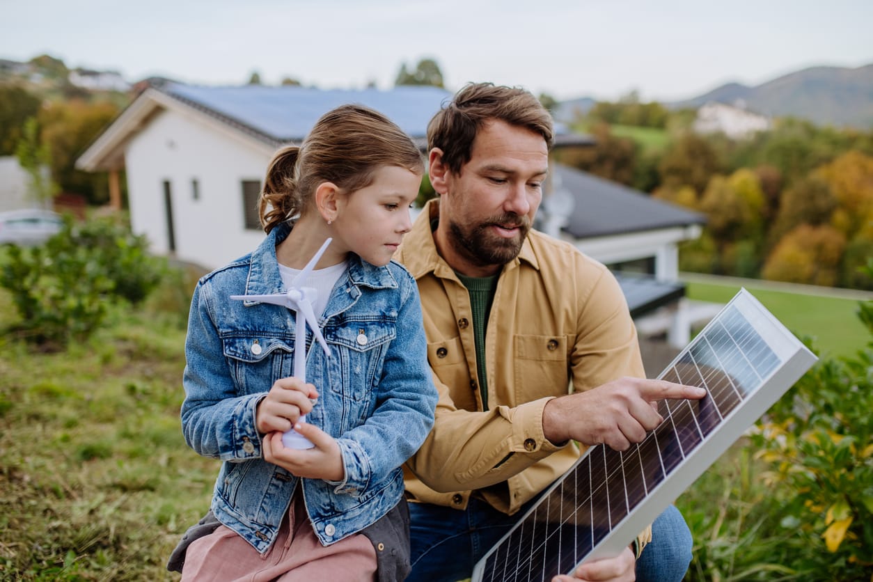 A father and daughter observing a solar panel, exploring renewable energy together.