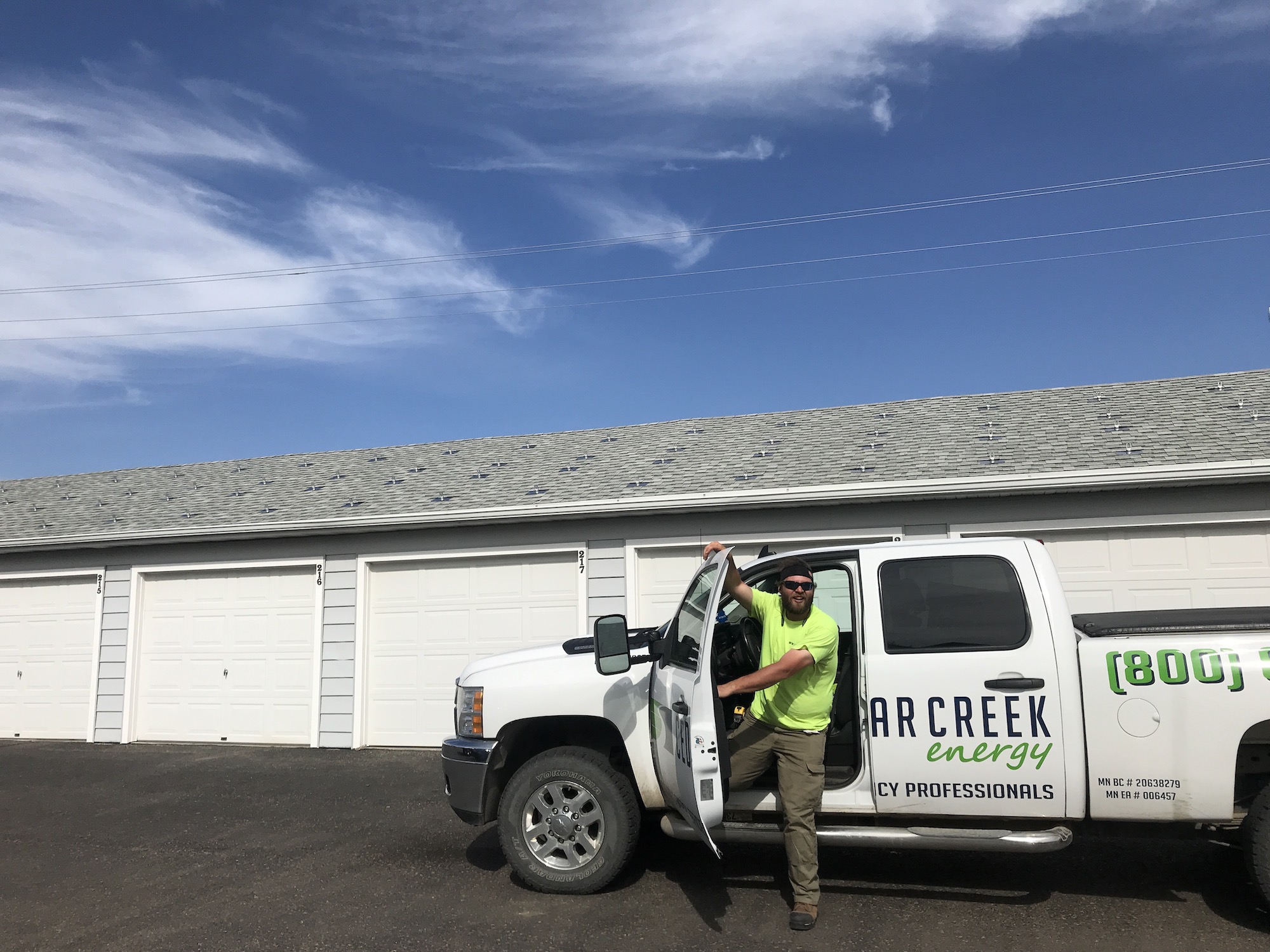 a man standing in the back of a white truck - Cedar Creek Energy