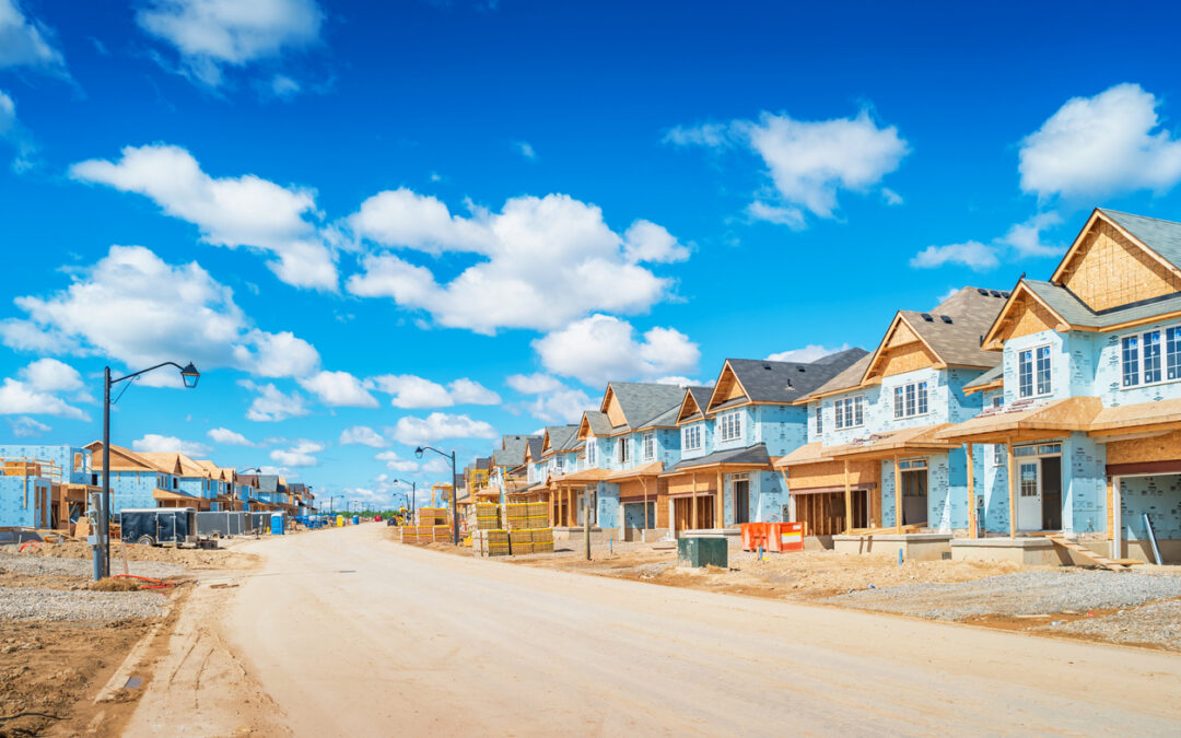 A row of houses under construction with solar panels on a blue sky. - Minnesota Solar Energy Company
