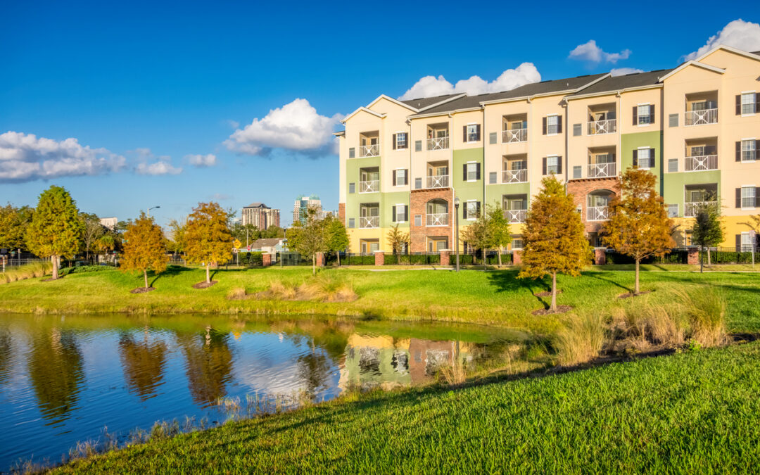 A multifamily housing complex with a pond in front of it, promoting sustainable living - Minnesota Solar Energy Company