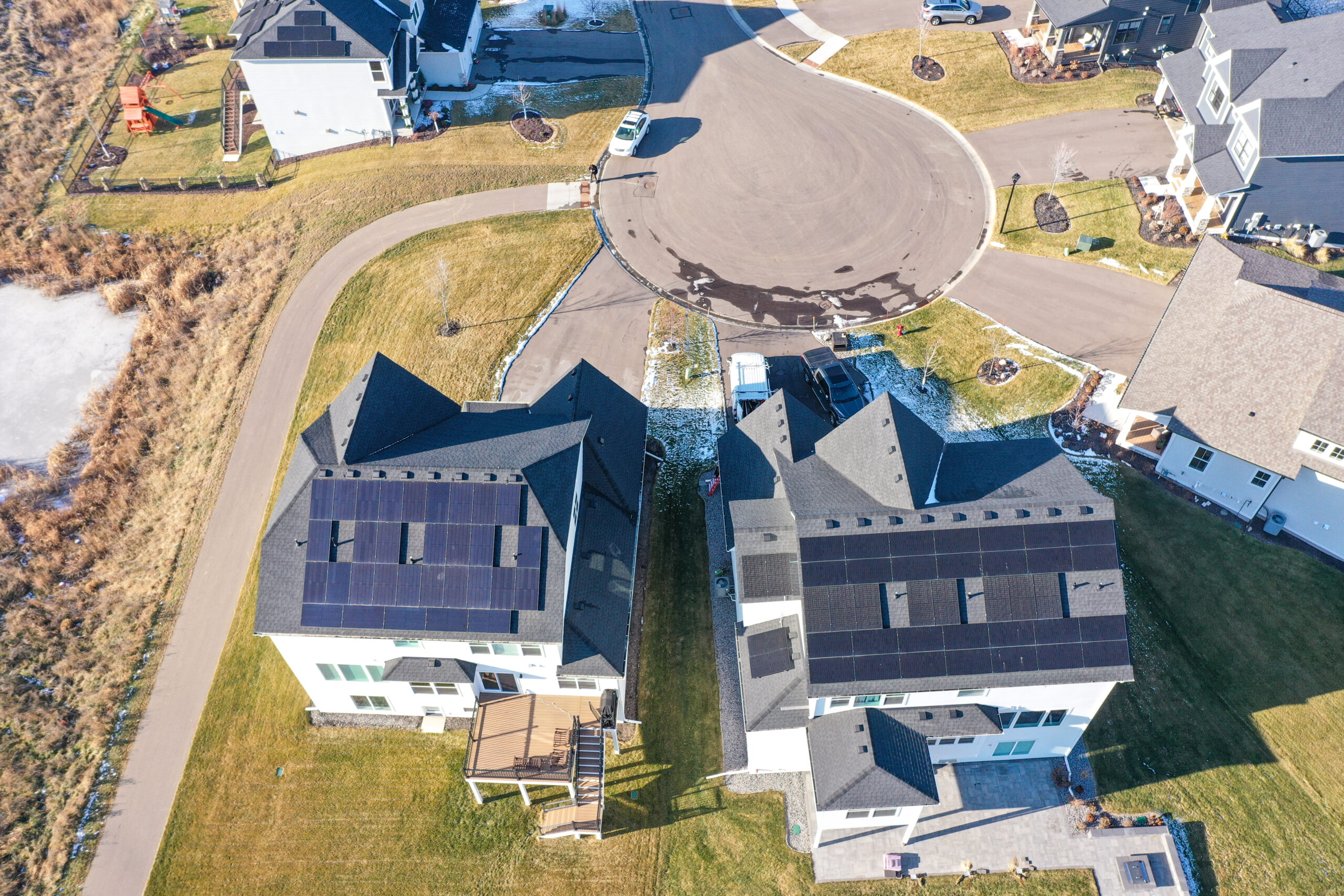 an aerial view of a house with solar panels producing solar energy