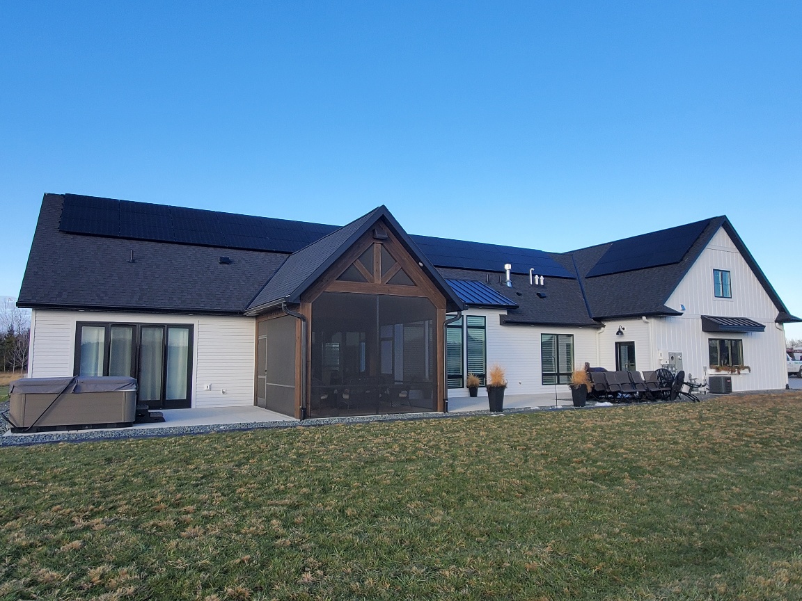 a large white house with a black roof - Home Solar Installers MN