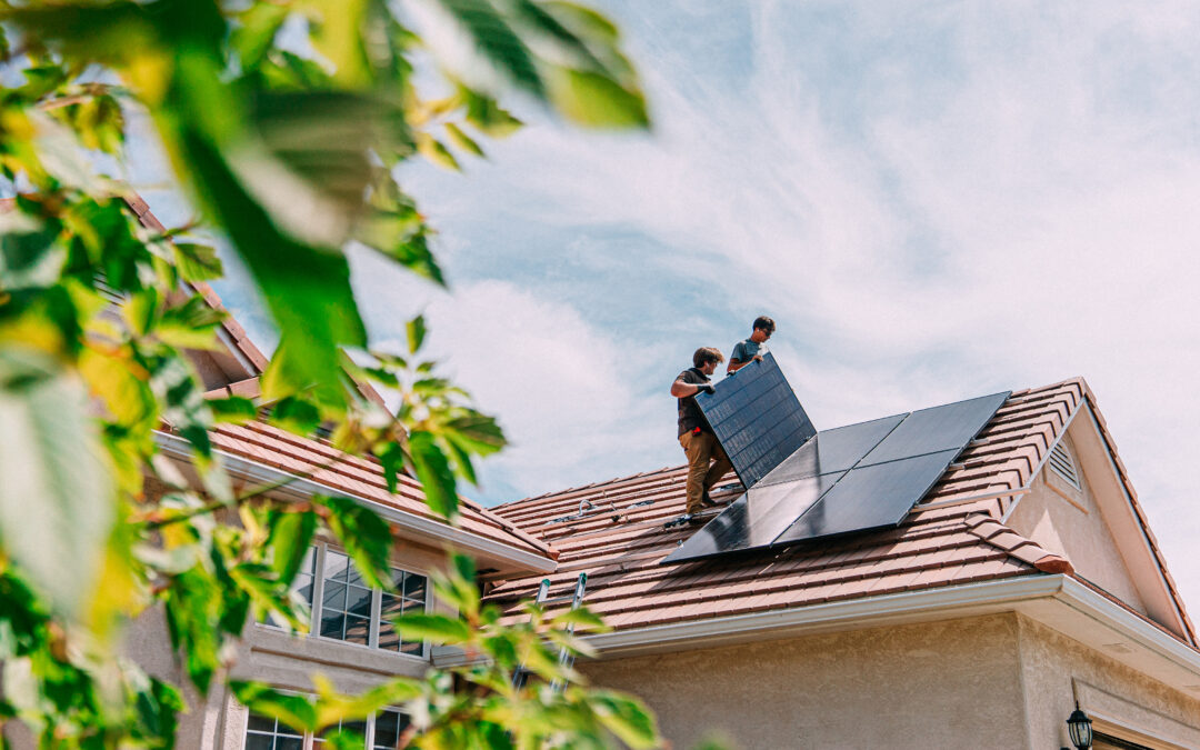 two men installing solar panels on a roof - Commercial Solar Panels Installer