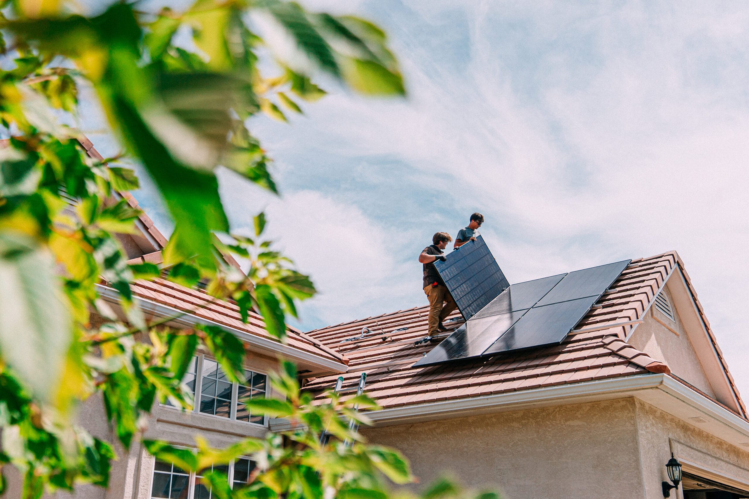 two men installing solar panels on a roof - Commercial Solar Panels Installer
