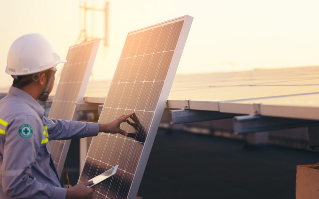 two men are installing solar panels on the roof of a building - Cedar Creek Energy